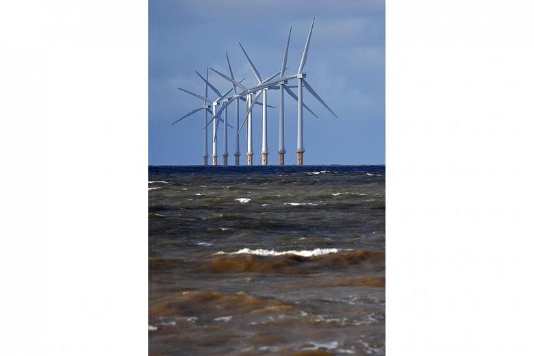 Wind turbines at the Burbo Bank Offshore Wind Farm, in north-west England. Such offshore turbines are becoming bigger and more efficient, and can power a home in Britain for two days with a single rotation. PHOTO: AGENCE FRANCE-PRESSE