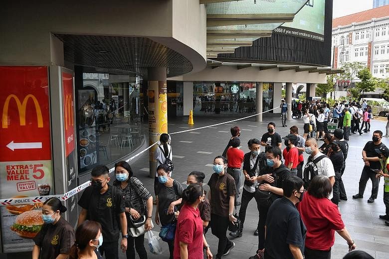 People outside Chinatown Point after it was evacuated yesterday. A spokesman for the mall's manager said there were no casualties in the fire, but an employee of the property suffered mild smoke inhalation. ST PHOTO: CHONG JUN LIANG