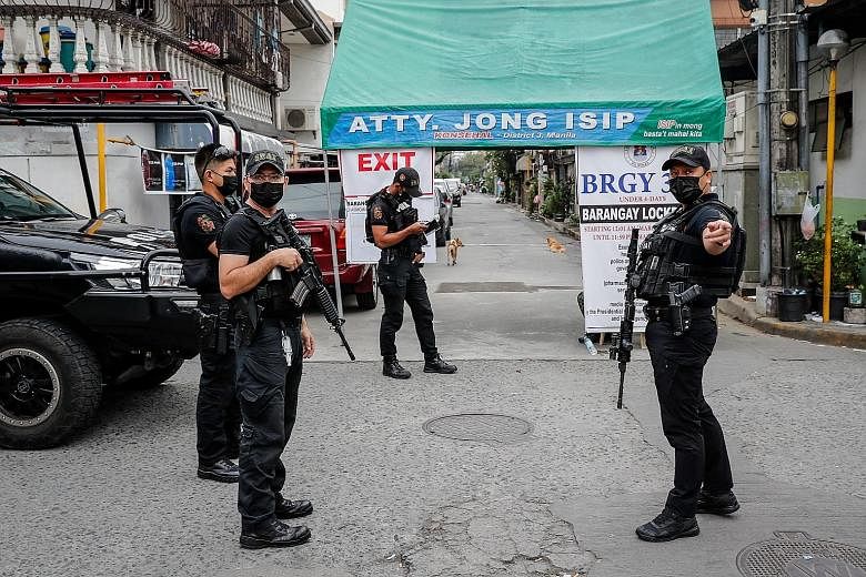 Security personnel patrolling a village under lockdown in the Metro Manila region on Friday. The Philippines is again tightening quarantine curbs after seeing a surge in infections in recent weeks, driven in part by the new variants of the coronaviru