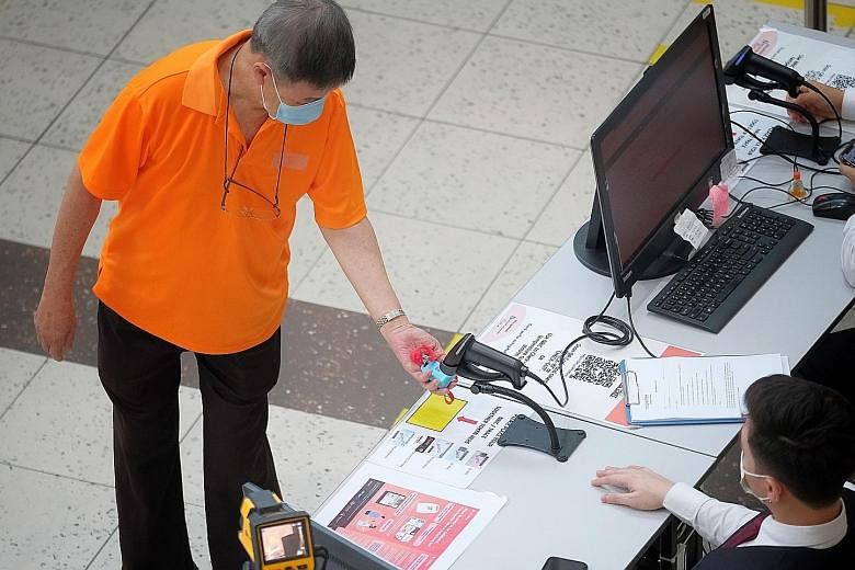A visitor scanning a TraceTogether token before entering HarbourFront Centre last month. TraceTogether, which identifies people in close contact with a Covid-19 patient via Bluetooth, came under the spotlight earlier this year when it was revealed th
