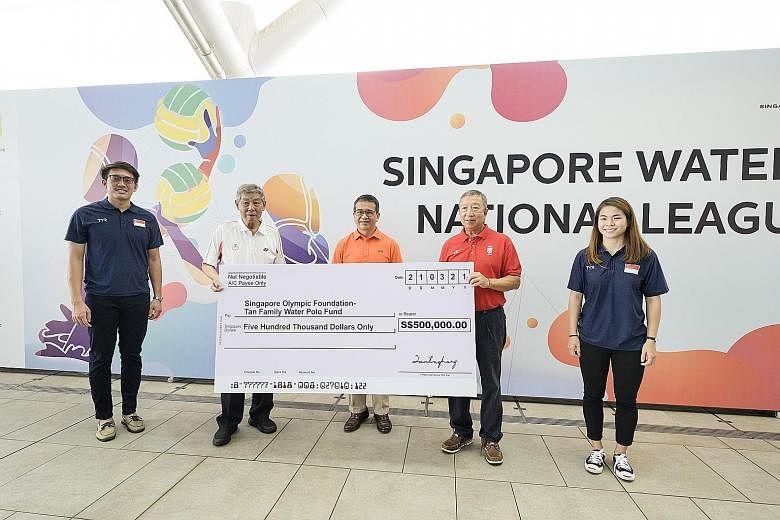 Tan Eng Liang (far left) handing over the mock cheque for $500,000 to Singapore Olympic Foundation chairman Ng Ser Miang. With them is Minister for Culture, Community and Youth Edwin Tong.