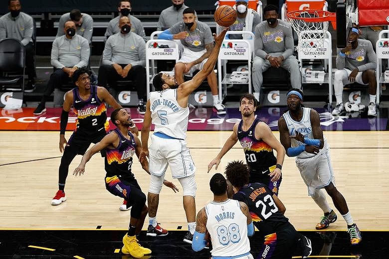 Talen Horton-Tucker (above) with a finger roll during Los Angeles' loss to Phoenix. The NBA champions were below par without the injured LeBron James (below).