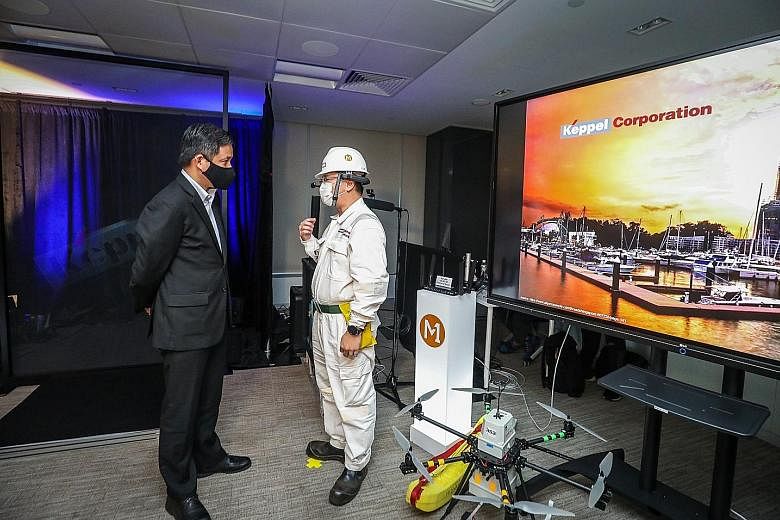 Trade and Industry Minister Chan Chun Sing at Keppel Corp's headquarters yesterday, viewing an exhibit showcasing the company's latest developments that are enabled by technology.