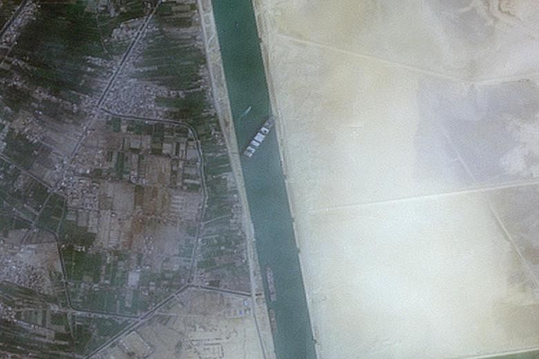 Tugs and diggers have so far failed to dislodge the 400m-long, 224,000-ton Ever Given, one of the world's largest container ships, after it ran aground on Tuesday in the Suez Canal, seen in a satellite image taken a day later. PHOTO: REUTERS
