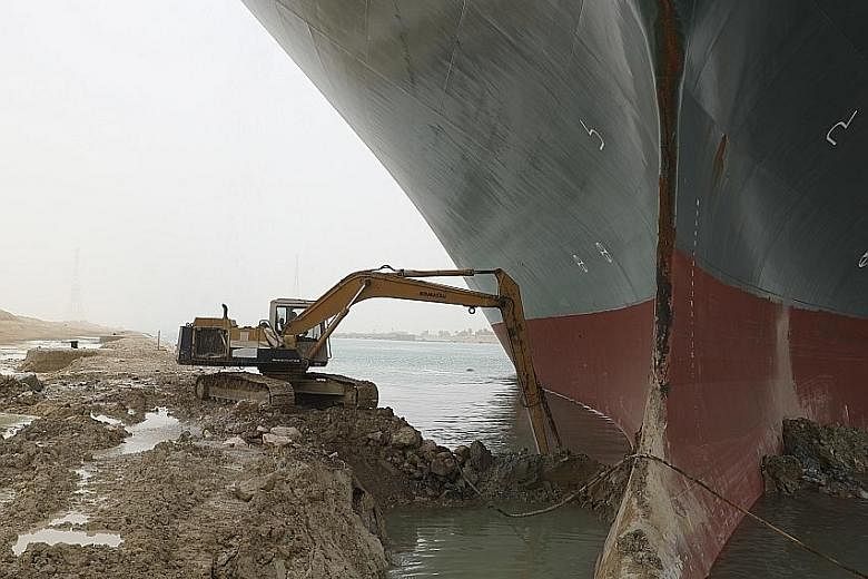 An excavator being used in an attempt to free the Ever Given container ship, which has been stuck in the Suez Canal since Tuesday. Work to refloat the stricken ship has so far been unsuccessful, with tugs and diggers failing to budge the giant, 400m-