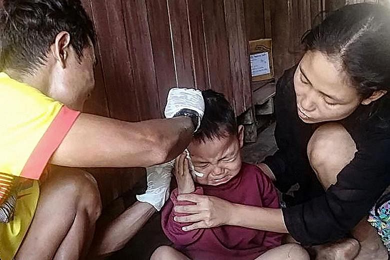 Saw Ta Eh Ka Lu Moo Taw, who is almost three years old, receiving medical treatment in a village in eastern Myanmar's Karen State after he was injured by shrapnel while sitting on the lap of his father, who was killed during an air strike in the area