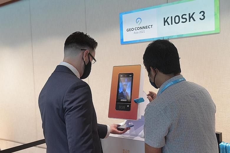 Above: A guest at Geo Connect Asia 2021, held last month, using a self-service kiosk with a facial recognition system that registers attendees without requiring face-to-face interaction. ST PHOTO: ALPHONSUS CHERN Left: The Professional Convention Man