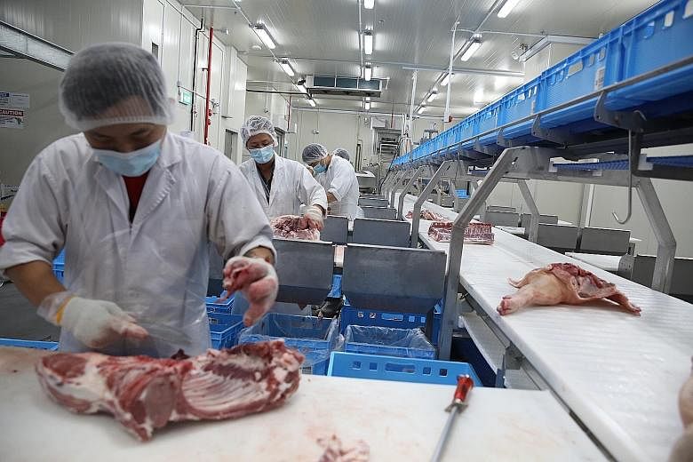 Staff of Tiong Lian Food processing meat at its facility in Pandan Loop. A new automation system has helped the firm to boost production capabilities. ST PHOTO: TIMOTHY DAVID