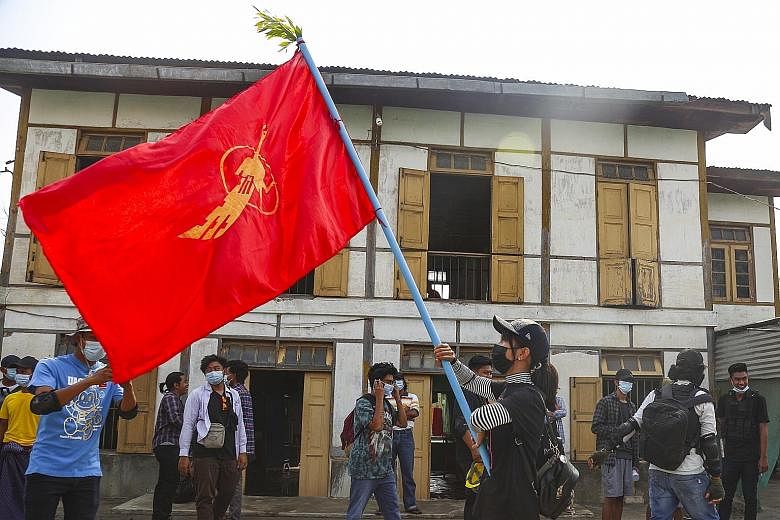 A demonstrator waving a student union flag during a protest yesterday in Mandalay against the military coup in Myanmar. The extent of the Internet shutdown was not immediately clear, with pictures of marches and a funeral of a slain protester still b