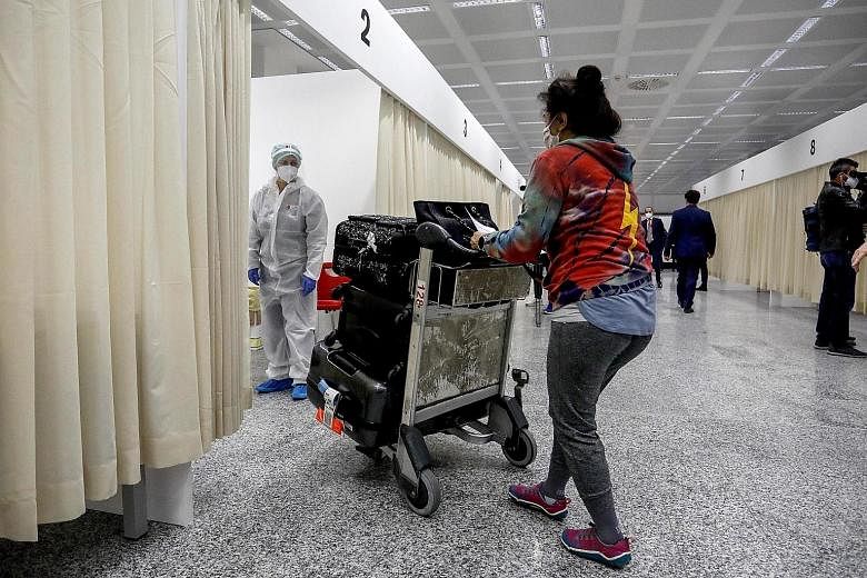 A passenger arriving from the United States on Covid-19-tested flights passing the first checks at Malpensa Airport in Ferno, Italy, yesterday. The US Centres for Disease Control and Prevention said fully vaccinated people do not need to be tested fo