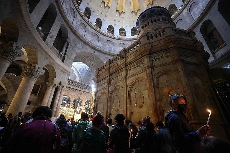 Worshippers at an Easter vigil Mass at the Church of the Holy Sepulchre in Jerusalem. Worship is muted across the world amid the pandemic, and even Pope Francis presided over a scaled-back "Way of the Cross" service in an empty St Peter's Square on G