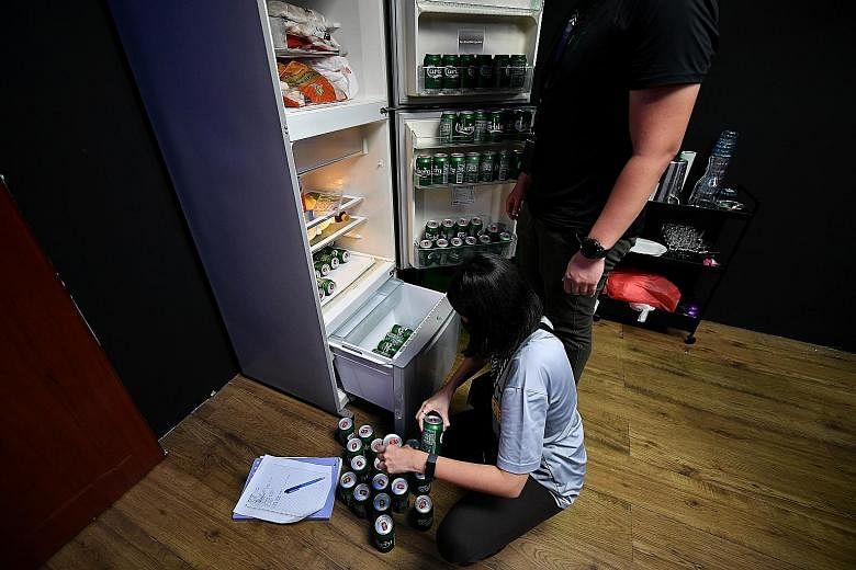 Above: A police officer counting cans of beer yesterday in a unit suspected of housing an unlicensed public entertainment outlet. Left: People being investigated during a raid. Besides the eight arrested, 34 men and 11 women will be probed for suspec