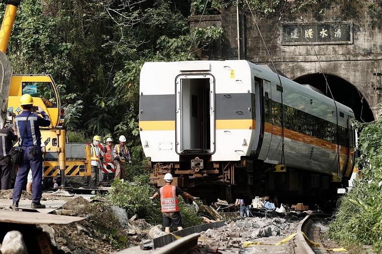 Parts of the train being removed yesterday. The Taiwan Railways Administration is working to dislodge the crumpled carriages that are still stuck in the tunnel. Relatives of the victims of Friday's deadly train accident visiting the site of the crash