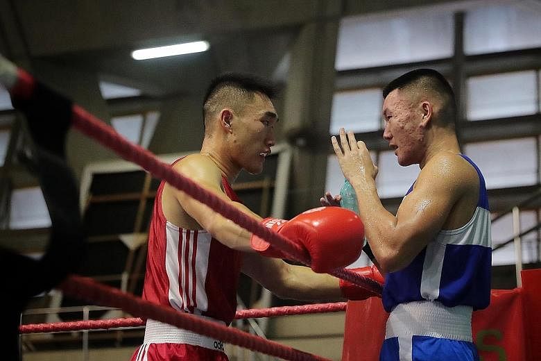 Left: Still fresh after winning his bout, Velvan Tan advises second brother Velco during the latter's fight. Above: Velco Tan getting the upper hand against Danish Husli.