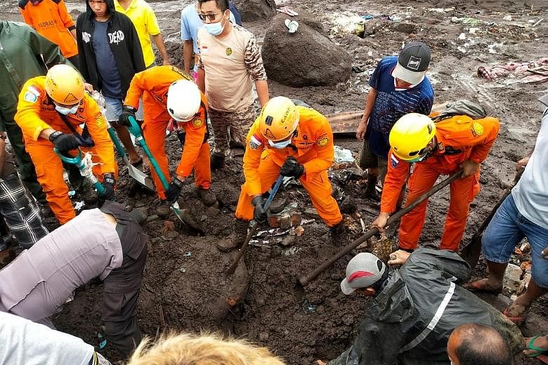 Rescue workers searching for a body in an area affected by flash floods after heavy rain in East Flores in Indonesia's East Nusa Tenggara province yesterday. At least 70 people in the country have died in flash floods and landslides, while over 30,00