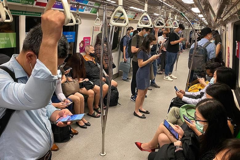 Commuters on a train heading towards the CBD at Outram Park MRT station yesterday at 8.30am. Although it was the first day of eased regulations giving companies more leeway to shift from working from home, most commuters The Straits Times spoke to di