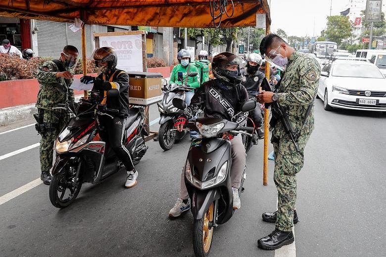 Police officers in the Philippines on Sunday manning a checkpoint between Quezon City and Manila, which is under lockdown. Police officers outside closed shops in Athens in February, during a lockdown. Aware of the toll of strict shutdowns on people 