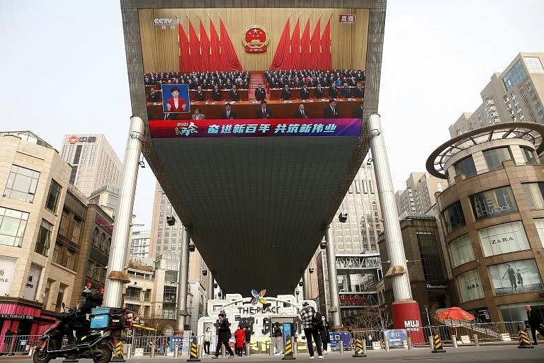 A giant screen showing Chinese President Xi Jinping at the National People's Congress in Beijing on March 11. Panellists at a forum in Singapore on Monday agreed that China would overtake the US as the world's largest economy, but not because of Chin