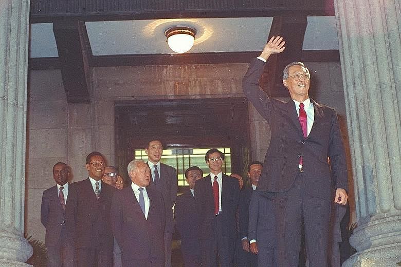 Above: Newly sworn-in Prime Minister Lee Hsien Loong shaking hands with Mr Goh Chok Tong, Singapore's second PM, on Aug 12, 2004, as then President S R Nathan looked on. Left: Prime Minister Goh waving to the crowd at the Padang after his swearing-in
