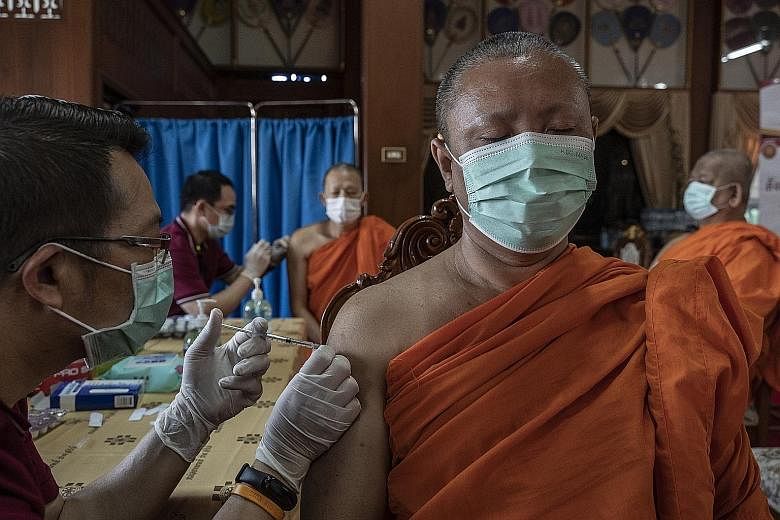 Thai monks receiving AstraZeneca's Covid-19 vaccine at a monastery in Bangkok on Wednesday. Reviews by British and European Union regulators have found potential links between the shot and rare blood clots. PHOTO: NYTIMES