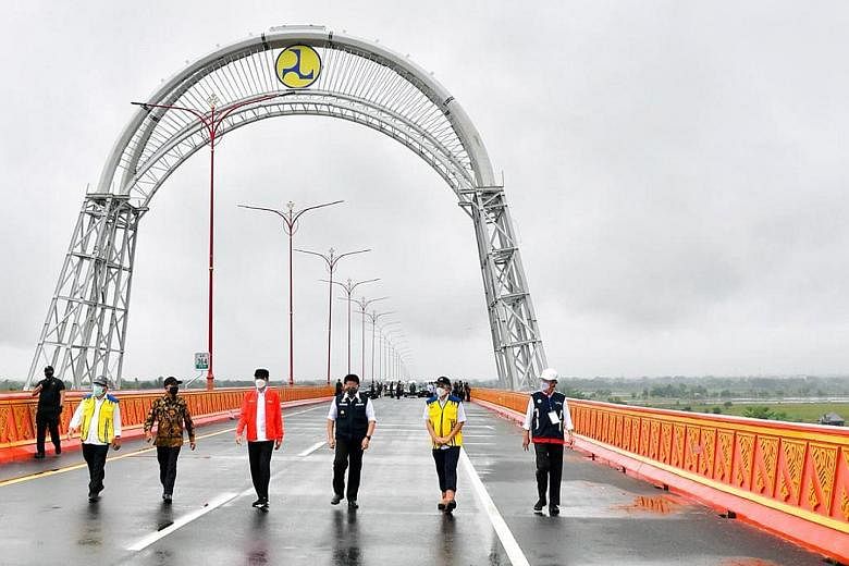 President Joko Widodo (in red) visiting the Trans-Sumatra Toll Road, Sumatra island's first highway targeted to be completed by 2024. It will connect Aceh province's northern tip to the southernmost province of Lampung.