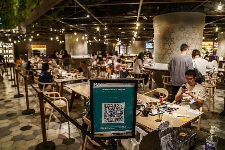 A QR code for a contact-tracing app in a Hong Kong foodcourt. Over 700,000 doses of the Covid-19 vaccine have been administered to the city's 7.5 million population but CEO Carrie Lam finds the figure unsatisfactory. The slow take-up rate is due main