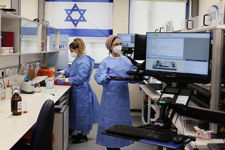Technicians at Maccabi Healthcare Services' Covid-19 public laboratory performing tests in Rehovot, Israel, on Feb 9. The researchers from Tel Aviv University and Israel's largest healthcare provider, Clalit, cautioned that the study had only a small