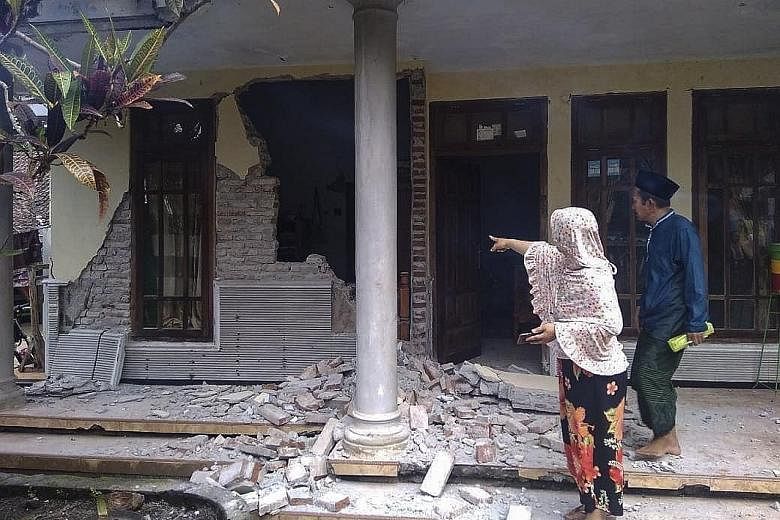 Residents examining the damaged wall of a house in Malang on Saturday. A resident salvaging his belongings from his house in Lumajang regency, in East Java province, yesterday. A man cleaning up a courtroom that was damaged in Saturday's earthquake i
