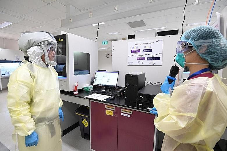 Deputy Prime Minister Heng Swee Keat (far left) visiting Stronghold Diagnostics Lab on Monday. The laboratory, a Covid-19 testing facility at Biopolis in Buona Vista, was set up to boost national polymerase chain reaction (PCR) testing capabilities, 