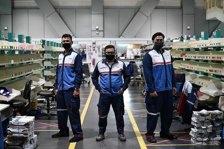 Singapore Post postmen (from left) Muhd Aizuddin Musa, 28, Azrizal Abd Malik, 33, and Khairul Faris Abdul Wahab, 29, are among the many Malaysian Muslim staff who chose to stay in Singapore for their jobs after Covid-19 travel restrictions were impos