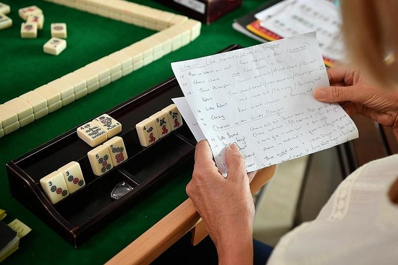 Ms Vishali Midha (above centre) invited her friends from the American Women's Association for a Holi-themed mahjong session. (Above) Handwritten notes and guidebooks on mahjong help Anza Mahjong Group members pick up the game. (Right) In Western-styl