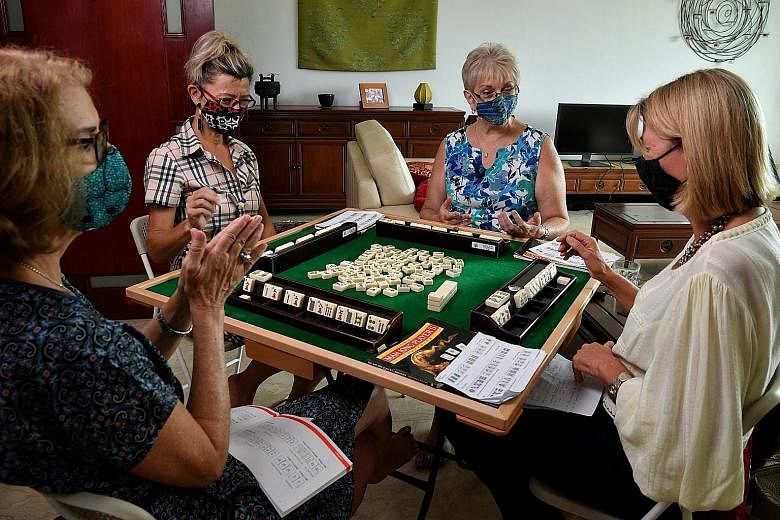 Ms Vishali Midha (above centre) invited her friends from the American Women's Association for a Holi-themed mahjong session. (Above) Handwritten notes and guidebooks on mahjong help Anza Mahjong Group members pick up the game. (Right) In Western-styl