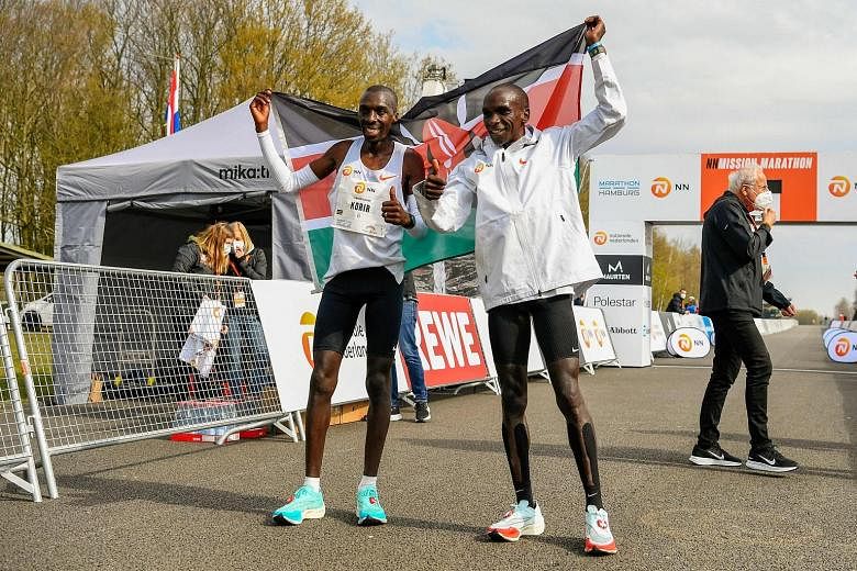 Kenya's Jonathan Korir and Olympic champion Eliud Kipchoge celebrating after finishing second and first respectively at the NN Mission Marathon in Enschede. The race was a qualifier for the Tokyo Games.