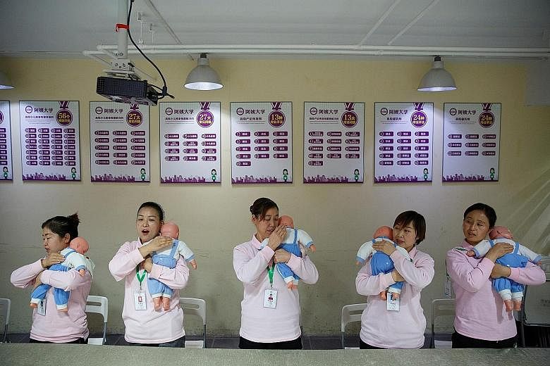 A file photo of students at a training programme for domestic helpers practising on dolls during a course teaching childcare in Beijing. The number of babies born in China fell by 580,000 to 14.65 million in 2019, and the birth rate of 10.48 per thou