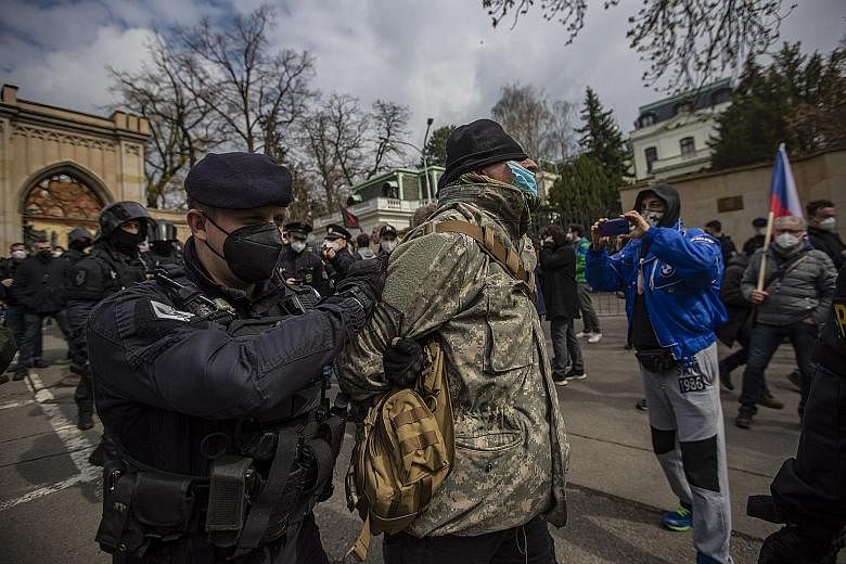 Riot police detaining a counter-protester in front of the Russian embassy in Prague on Sunday. Demonstrators have been calling attention to the deaths of two people in a 2014 arms depot explosion the Czechs now blame on Russian agents.