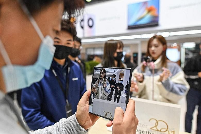 Left: A visitor checking out the Huawei Mate X2 at a booth during the Mobile World Congress in Shanghai in February. The Chinese company has said that it has expanded the number of apps that work with its devices, with more than 120,000 as at the end