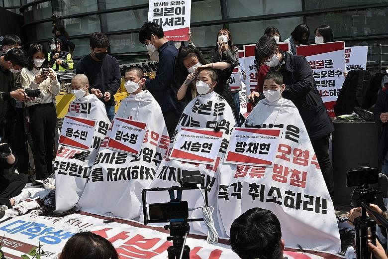 South Korean college students having their heads shaved outside the Japanese embassy in Seoul yesterday in protest against Japan's decision to release treated water from its crippled Fukushima nuclear plant into the sea. Japan last week said it will 