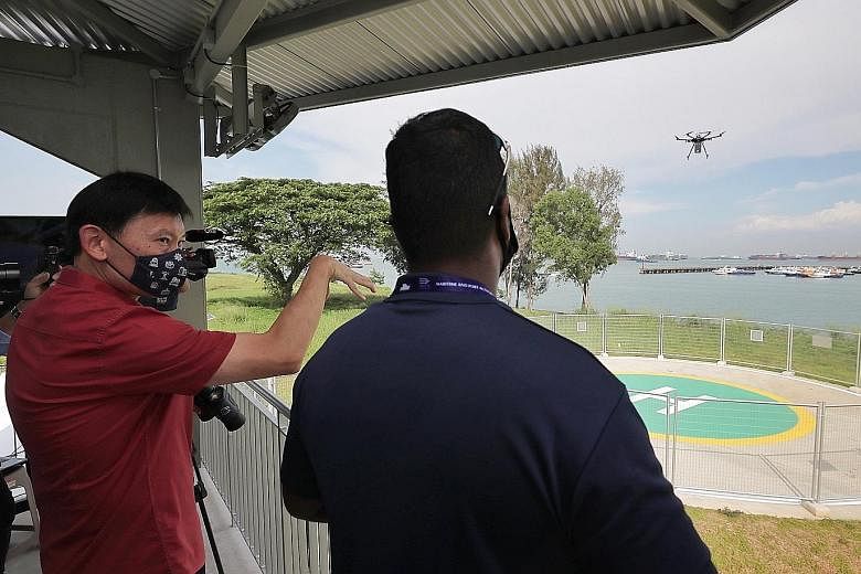 Senior Minister of State for Foreign Affairs and Transport Chee Hong Tat at the Maritime Drone Estate near Marina South Pier yesterday as a drone took off to deliver a package to a ship anchored offshore. The new space will enable maritime drone flie