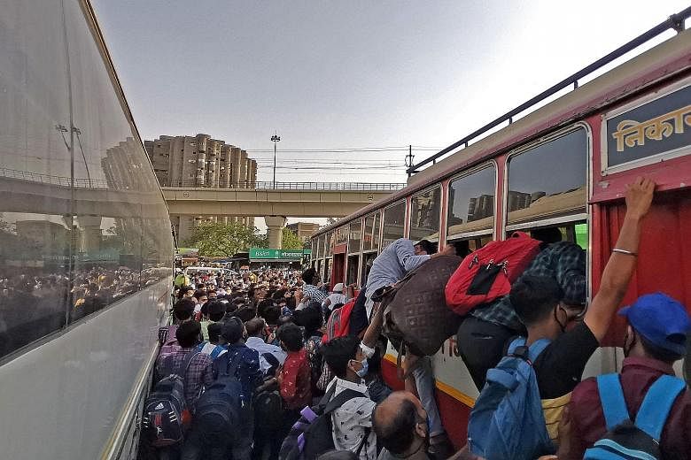 RUSHING TO GET HOME Crowds of people at a bus station in New Delhi, hours before a week-long lockdown ordered by the Delhi government came into effect in the Indian capital on Monday night. More countries are suspending travel links with India as it 
