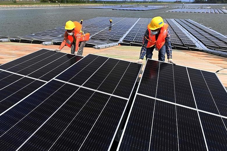 Workers at a solar power farm in Singapore. The Republic placed 21st globally in WEF's Energy Transition Index 2021, ahead of major economies like the US and Canada. PHOTO: AGENCE FRANCE-PRESSE