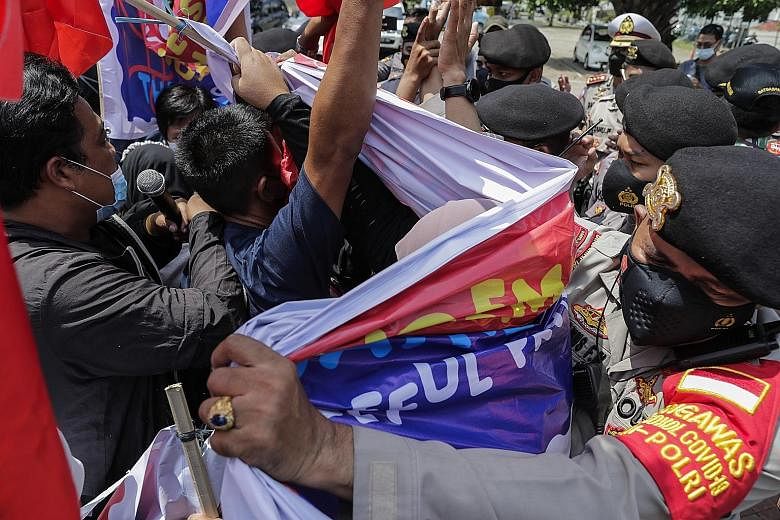 Police officers dispersing protesters during a rally against Myanmar's junta near the Asean secretariat ahead of the Asean leaders' meeting in Jakarta yesterday. PM Lee Hsien Loong said Asean can, and wishes to, play a constructive role to facilitate