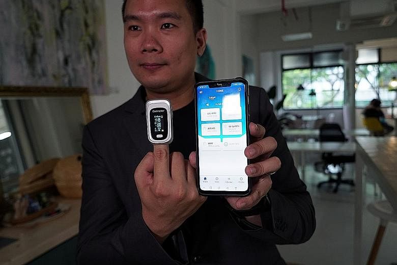 Nervotec founder Jonathan Lau showing the comparison in readings of vital signs between his company's app (right) and a pulse oxygen monitor. The app can record other health data such as temperature logs and symptoms.