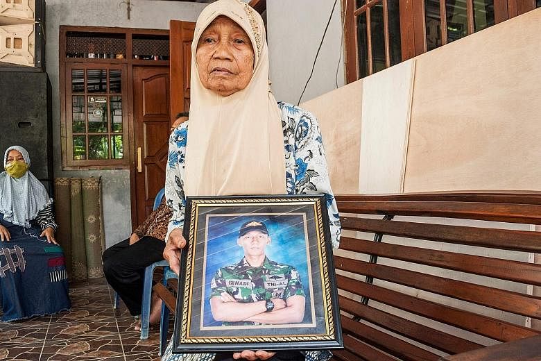 Family members of two of the submariners who died when the KRI Nanggala-402 submarine sank last Wednesday, showing photographs of their loved ones. Families of the crew have called for the Indonesian authorities to retrieve the bodies from the sea. P