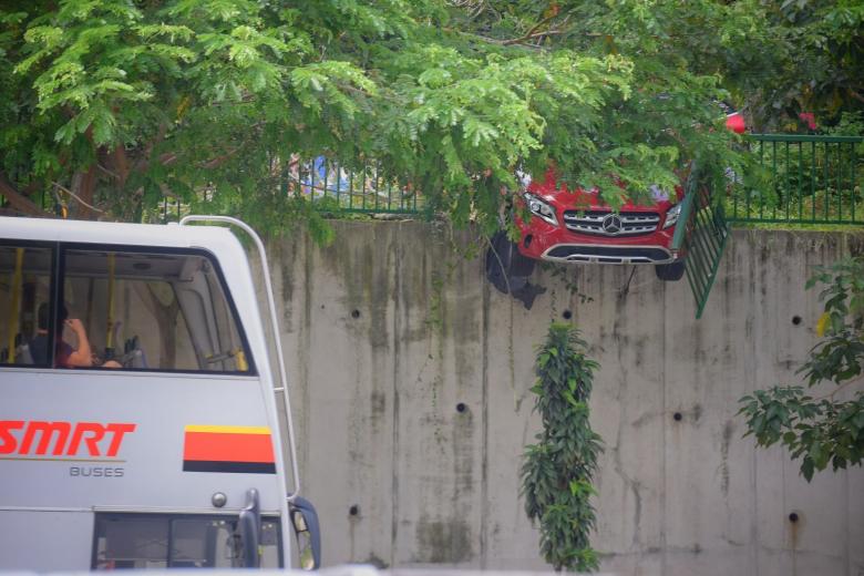 Car crashes through railing, hangs precariously over road | The Straits ...