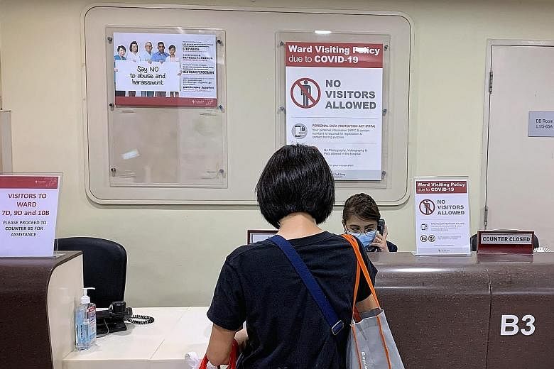 A woman at the visitor registration counter at Tan Tock Seng Hospital yesterday evening. A cluster emerged at the hospital following a positive diagnosis on Tuesday of a nurse who works in a general ward. TTSH has since stopped allowing in all visito