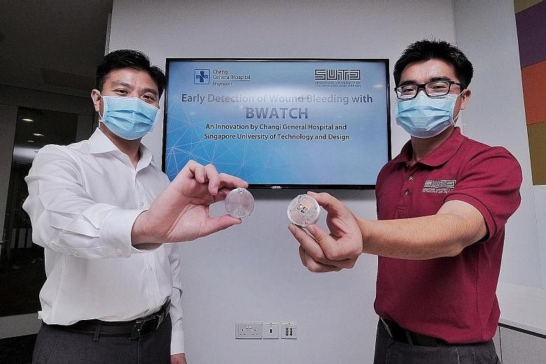 Changi General Hospital's Associate Professor Chionh Chang Yin (far left) and Singapore University of Technology and Design's Associate Professor Foong Shaohui with the BWATCH sensor. The wireless, lightweight device is placed over a patient's bandag