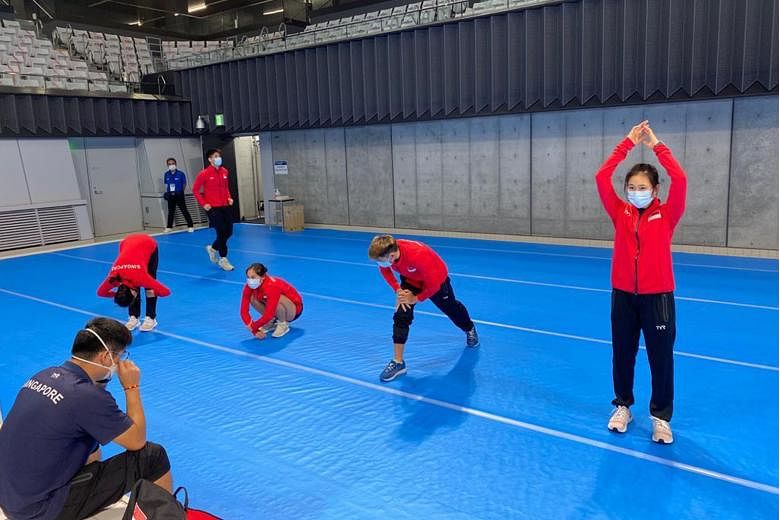 Above: Team Singapore divers at their training session held at the Tokyo Aquatics Centre ahead of the May 1-6 Fina Diving World Cup. Left: The divers keep their distance and their masks on even when they are stretching during training.