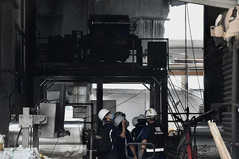 A fire investigation team at the site of the incident in Tuas Avenue 11 the day after the Feb 24 fire. The Ministry of Manpower's preliminary investigations found that the explosion was caused by the accumulation of potato starch in a confined enviro