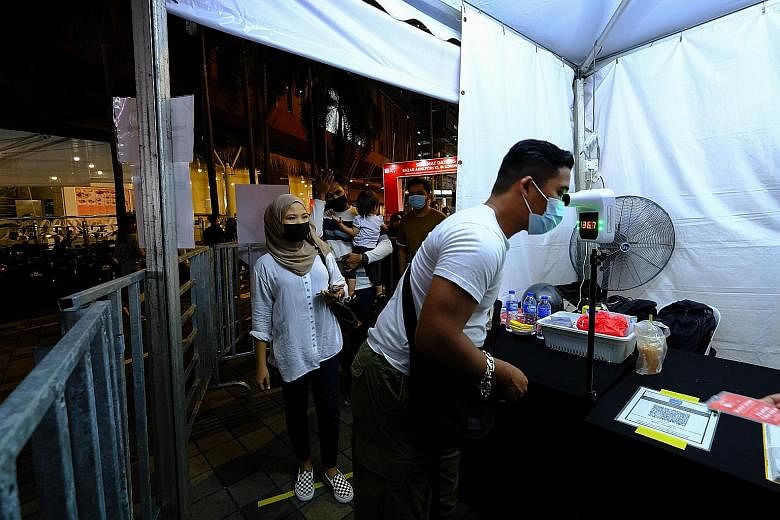 People queueing to have their temperature taken before entering a Ramadan market in Kuala Lumpur last Friday. Malaysia's health chief has warned that hospitals around the Klang Valley, where the capital is located, are running out of beds for critica
