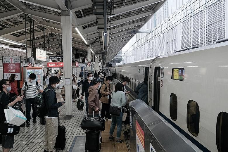 Passengers boarding a bullet train in Tokyo at the start of the Golden Week holidays last Thursday, amid a state of emergency. Japan logged 5,879 new Covid-19 cases yesterday as its overall tally crossed 600,000.
